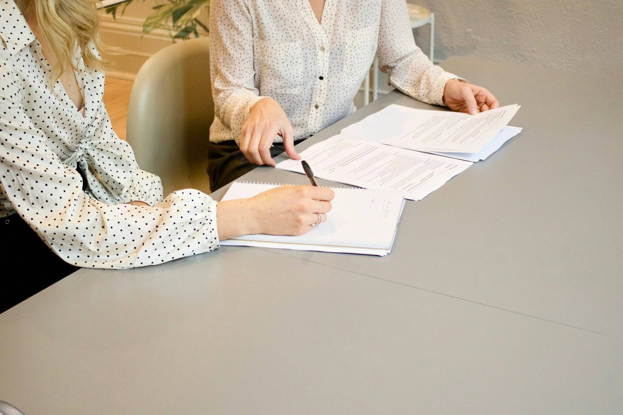 Due persone firmano un contratto su un tavolo